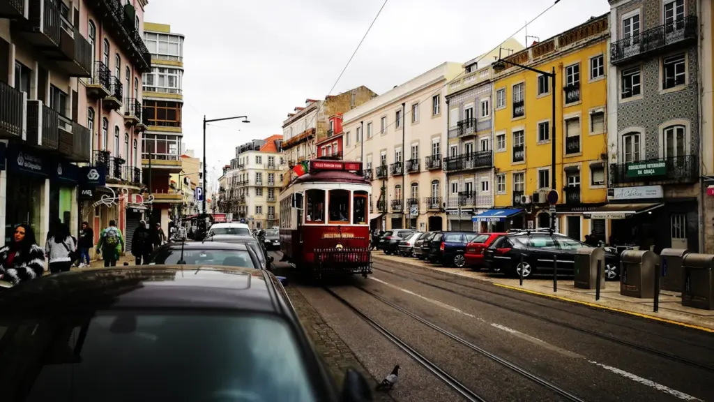 Kustīgs tramvajs vēsturiskā pilsētas ielā, kas piemērots tehniskas iekārtas transportēšanai.