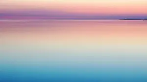 Mierīga un maiga horizonta līnija virs klusa ūdens rožainās vakara krāsās.